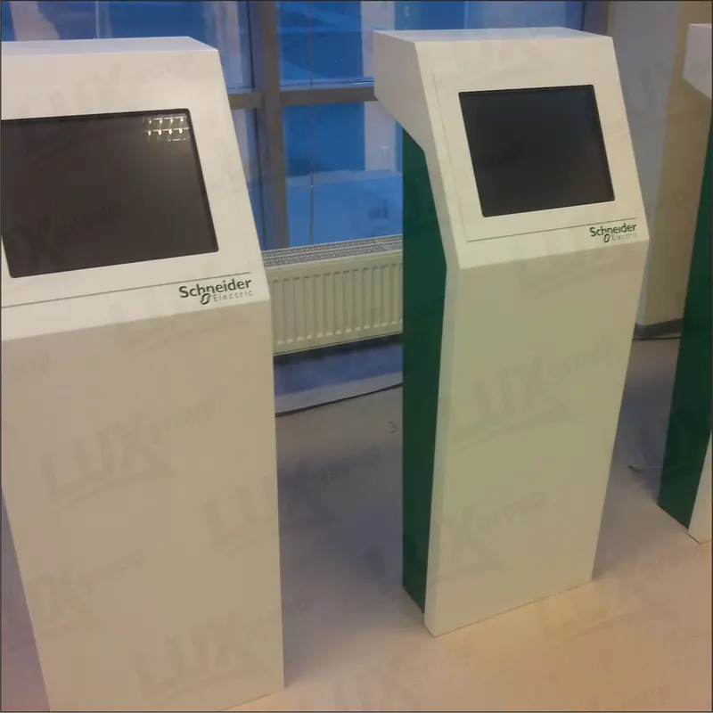 Два напольных информационных терминала Schneider Electric с тёмными экранами, белыми корпусами и зелёными боковыми панелями.