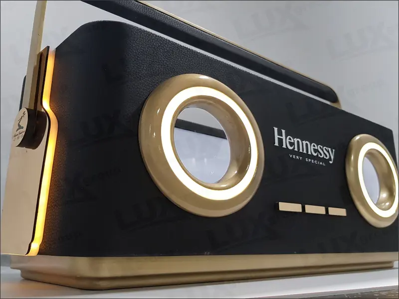 Фрагмент брендированной витрины Hennessy VERY SPECIAL с чёрной панелью, золотистой окантовкой и круглыми световыми элементами.